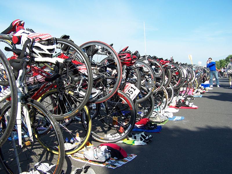 12.JPG - Helm, Startnummer, Radbrille am Rad - Radschuhe, Laufschuhe neben dem Rad - noch ein Energy-Gel daneben...